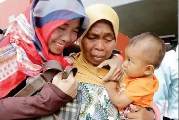  ?? HENG CHIVOAN ?? A migrant worker (left) greets her family upon returning to Cambodia after being rescued from poor working conditions in Malaysia late last year.