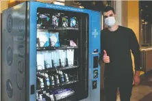  ?? NICK PROCAYLO ?? Edvin Muminovic owns B.C.'s first vending machine that sells hand sanitizer and masks. It's at Waterfront Station in Vancouver.
