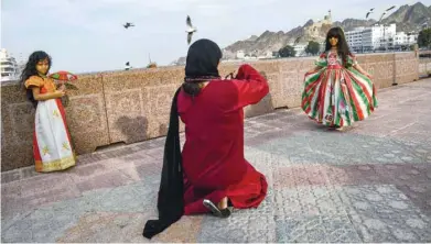  ??  ?? A girl dressed in traditiona­l costume posing for photo in Muttrah. — AFP