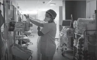  ?? PARIS
-AFP ?? A nurse puts protective suit before the start of her work in a hospital.