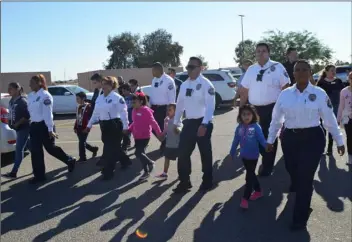  ?? JULIO MORALES PHOTO ?? Calexico Police Department personnel escort local children to the Wal-Mart Supercente­r on Monday during the department’s 14th annual Kids ‘N’ Badges program, which provided 30 children with breakfast and a $100 shopping spree.
