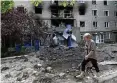  ?? AFP ?? Eine Frau läuft über eine zerstörte Straße in Siwersk, Donbass.