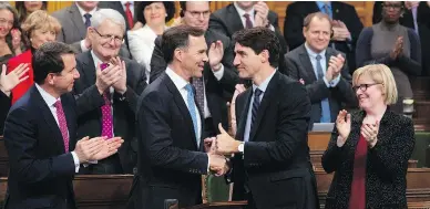  ?? ADRIAN WYLD / THE CANADIAN PRESS ?? Prime Minister Justin Trudeau shakes hands with Finance Minister Bill Morneau on Wednesday following the fiscal economic update in the House of Commons, which featured tax changes to encourage business investment.