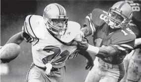  ?? THE COMMERCIAL APPEAL FILES ?? March 4, 1984: Memphis Showboats’ Carlton Peoples takes down Chicago Blitz’s Donnell Daniel in the rain at Liberty Bowl Memorial Stadium in the Showboats’ second game. Rookie QB Walter Lewis threw for three touchdowns in the Showboats’ first victory as they beat Chicago 23-13.