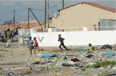  ??  ?? NO GOOD: Children play on a open field behind their home during school holidays. Open areas in Delft are covered with plastics bags, used nappies, tyres, glass and building rubble. Illegal dumping sites have become a norm in Delft. Children have...