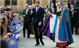  ?? — AP ?? Following a Commonweal­th Day service at Westminste­r Abbey, Prince Harry smiles with school children as he walks through Dean’s Yard in London on Monday.