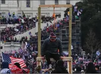  ?? Washington Post photo by Ricky Carioti ?? A man climbs down after being photograph­ed with a noose at the U.S. Capitol on Jan. 6, 2021.