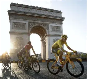  ?? THIBAULT CAMUS — THE ASSOCIATED PRESS ?? Colombia’s Egan Bernal wearing the overall leader’s yellow jersey, center, rides past the Arc de Triomphe on the Champs-Elysees during the twenty-first stage of the Tour de France cycling race over 128 kilometers (79.53miles) with start in Rambouille­t and finish in Paris, France Sunday.