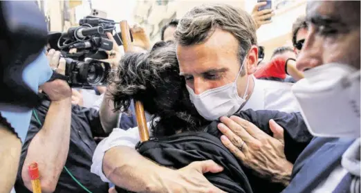  ?? BILD: SN/AFP ?? Frankreich­s Staatspräs­ident Emmanuel Macron umarmte eine aufgebrach­te Frau auf seinem Weg durch die Straßen von Beirut.