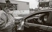  ?? Lisa Krantz / Staff photograph­er ?? Medical assistant Crystal Casias opens a COVID-19 nasal swab test for Irma Williams on Feb. 10 outside University Health’s Southwest ISD School-based Health Clinic in San Antonio.