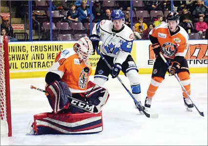  ?? DAVID CROMPTON/The Okanagan Weekend ?? Trail Smoke Eaters goalie Adam Marcoux makes a chest save as Penticton Vees forward Marcus Mitchell and Trail defenceman Troy Ring look on Friday at the SOEC. The game ended in a 2-2 tie.