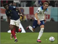  ?? FRANK AUGSTEIN — THE ASSOCIATED PRESS ?? England’s Harry Kane, right, and France’s Aurelien Tchouameni challenge for the ball during their quarterfin­al match Saturday at Al Bayt Stadium in Al Khor, Qatar.