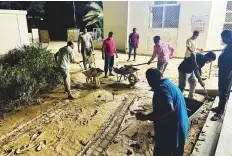  ?? ?? ■ Right: ICF volunteers clean up sludge from the premises of Jaber Saeed Ali Jaber Masjid in Hili, Al Ain, on Thursday night.