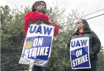  ?? BLOOMBERG ?? Members of the United Auto Workers hold ‘UAW on Strike’ signs outside General Motors Co’s plant in Romulus, Michigan on Friday.