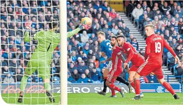  ??  ?? Dons keeper Joe Lewis is alert to stop a Scott Arfield effort