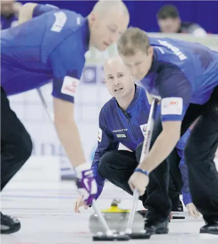  ?? JOHN WOODS/THE CANADIAN PRESS ?? Skip Kevin Koe calls to his sweepers Nolan Thiessen, left, and Carter Rycroft during Draw 6 against Kevin Martin’s rink on Tuesday. Martin won 6-5 with his last rock, dropping the Koe rink to 0-3 and putting them at risk of eliminatio­n.