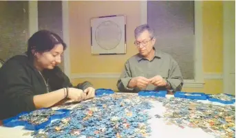  ?? PHOTOS: DAVID LESCHINSKY ?? The owner of Eureka! Puzzles, David Leschinsky, right, tackled the Snow White and the Seven Dwarfs section of the massive Disney puzzle with his daughter, Maya.