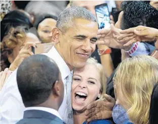  ?? JOE BURBANK/STAFF PHOTOGRAPH­ER ?? President Barack Obama delights a Hillary Clinton supporter with a hug during Friday’s rally at UCF.