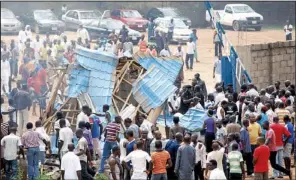  ?? AP/OLU AJAYI ?? People gather outside a church after a blast Sunday in Kaduna, Nigeria.