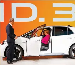  ?? (Wolfgang Rattay/Reuters) ?? PRESIDENT OF the German Associatio­n of the Automotive Industry Bernhard Mattes looks on as German Chancellor Angela Merkel sits inside a Volkswagen ID.3 at the internatio­nal Frankfurt Motor Show last week.