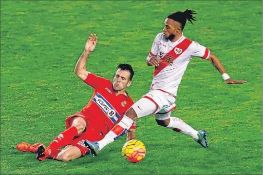  ?? JUANJO MARTIN / EFE ?? El rayista Lass disputa el balón con Fuentes en un lance del partido de anoche en Vallecas