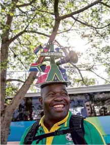  ??  ?? Sul-africano sorri ao desembarca­r no alojamento dos atletas