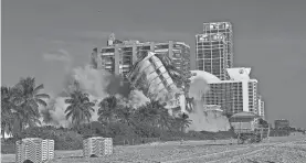 ?? CARL JUSTE/MIAMI HERALD VIA AP ?? The 17-story hotel tower of the historic Deauville Beach Resort implodes, sending out a dust cloud full of debris Sunday.