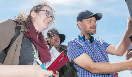  ?? MICHAEL BELL/FILES ?? Script supervisor Mary Berntson, actor Jay Reso and director Lowell Dean watch a scene being filmed on the set of Supergrid near Regina last June. The film will premiere this weekend in Calgary. The movie is slated to screen in Saskatoon in mid-november.