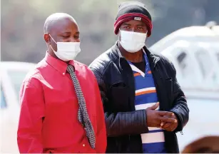  ?? — Picture: Lee Maidza ?? Michael Mandaza (right) arrives at the Harare Magistrate­s Court yesterday escorted by a police detective.