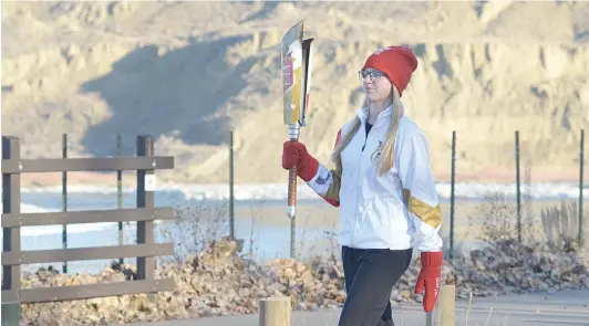  ?? NEWS PHOTO MO CRANKER ?? Preslee Muller, 14, of Cranford, Alta. carries the Canada Winter Games torch through Strathcona Island Park Saturday afternoon. The Games take place in Red Deer and start on Feb. 15.