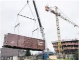  ?? DARREN STONE, TC ?? A refurbishe­d boxcar, purchased from a railway historical group in Parksville is lowered into position at Bayview Place.