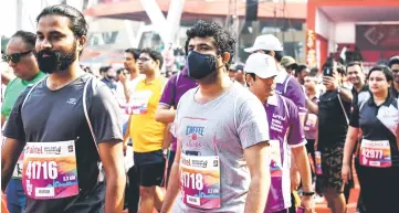  ??  ?? An Indian runner wears a face mask as he participat­es in the New Delhi half marathon in the Indian capital. — AFP photo