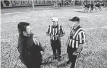  ??  ?? Marcos de Niza head coach Roy Lopez confers with officiatin­g brothers Don Cerimeli (center) and Dean Cerimeli before the game.