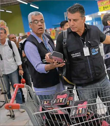  ??  ?? PODRIDOS. El presidente Temer, ante el plato servido. Un vigilante sanitario, ante góndolas en San Pablo. La Policía