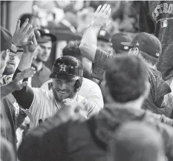  ?? Karen Warren / Staff photograph­er ?? Catcher Max Stassi is greeted warmly in the dugout after scoring on Trevor Cahill’s bases-loaded walk to Alex Bregman to put the Astros up 4-3 in the fourth inning Wednesday.