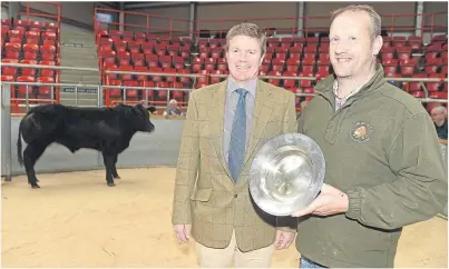  ??  ?? PRIZE: Mark Munro, right, of Invercharr­on Farm, Ardgay, with Martin Mackay of show sponsor Brodies LLP