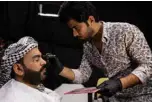  ??  ?? Iraqi actor Ayad Al-Atabi, (left), gets his makeup done on the set of a parody sketch video of Bab Al-Hara.