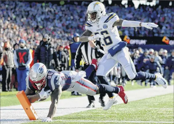  ?? Photos by Adam Glanzman / Getty Images ?? The Patriots’ Sony Michel ran for 129 yards against the Chargers, including this touchdown, one of his three in their AFC Divisional Playoff matchup.