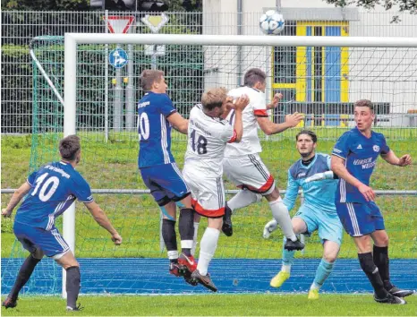  ?? FOTO: HKB ?? Die Mühlheimer waren beim SC 04 Tuttlingen harmlos. Auch diese Flanke brachten weder Stefan Rebholz noch Maximilian Bell (weiß von links) im Tor unter. Die Gastgeber (blau), von links Carlos Hehl, Hannes Zeyher, Torhüter Alex Burdun und Patrick Renner,...