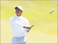  ?? Sam Greenwood / Getty Images ?? Tiger Woods plays his second shot on the ninth hole during the second round of the Valspar Championsh­ip Friday at Innisbrook Resort Copperhead Course in Palm Harbor, Fla.