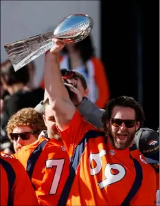  ??  ?? Denver Broncos guard Evan Mathis holds up the Lombardi Trophy at a rally following a parade through downtown Denver on Tuesday. Fans crowded into Denver’s downtown to salute the Broncos for the team’s victory over the Carolina Panthers in Super Bowl 50.