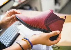  ??  ?? Tellis displays a ruby-colored version of Betabrand’s Tennis-Western Boot. The clothing firm uses crowdfundi­ng.