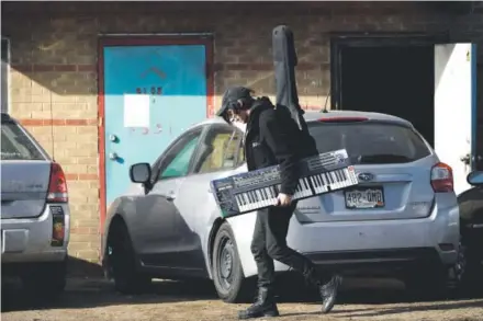  ??  ?? Tom, a Rhinocerop­olis resident and musician carries instrument­s to his car before Denver fire safety and city officials inspect the DIY venue and studio space for artists and musicians. Photos by Joe Amon, The Denver Post