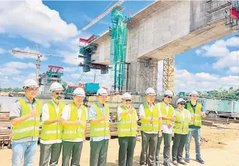  ?? ?? Uggah (centre) and Penguang (fourth left) show their approval for the progress of constructi­on for Marudi bridge.