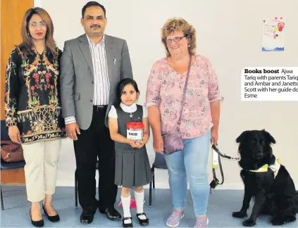  ??  ?? Books boost Ajwa Tariq with parents Tariq and Ambar and Janette Scott with her guide dog Esme