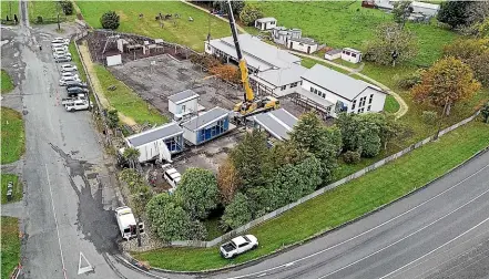  ?? PHOTOS: WARWICK SMITH/STUFF ?? A crane lowers part of Mangataino­ka School’s new roll-growth classroom into place.