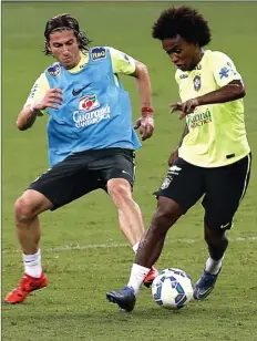  ?? PAULO WHITAKER/REUTERS ?? SERIUS: Filipe Luis (kiri) berlatih bersama Willian di Arena Castelao, Fortaleza, menjelang laga kualifikas­i Piala Dunia melawan Venezuela.
midfielder.