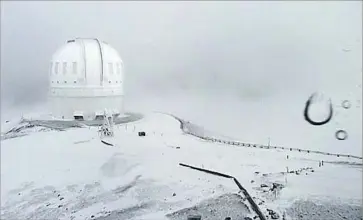  ?? Associated Press ?? THE SUMMIT of Mauna Kea on Hawaii is covered in snow in an image taken from video provided by the Canada-France-Hawaii Telescope. Two or 3 feet of snow in just a few days is unusual for the Big Island.