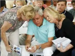  ?? PATRICK SEMANSKY — THE ASSOCIATED PRESS ?? Carl Hiaasen, center, brother of Rob Hiaasen, one of the journalist­s killed in the shooting at The Capital Gazette newspaper offices, is consoled by his sisters Barb, left, and Judy during a memorial service, Monday in Owings Mills, Md.