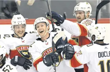  ?? BILL KOSTROUN AP ?? Panthers defenseman Gustav Forsling, center, gets mobbed by teammates Brandon Montour, left, Aleksander Barkov and Anthony Duclair after scoring in overtime to cap a come-from-behind win on Saturday afternoon in Sunrise.